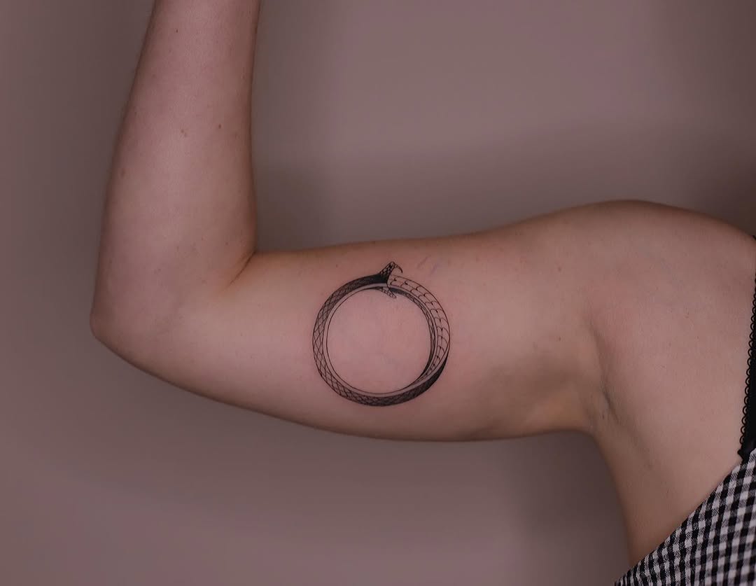 Striking minimalist ouroboros tattoo on arm