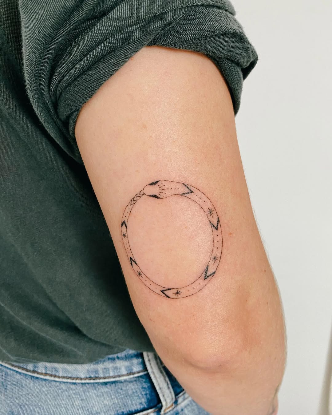 Minimalist ouroboros tattoo symbolizes eternity