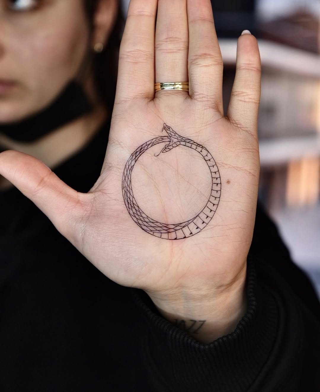 Symbolic ouroboros tattoo on palm design