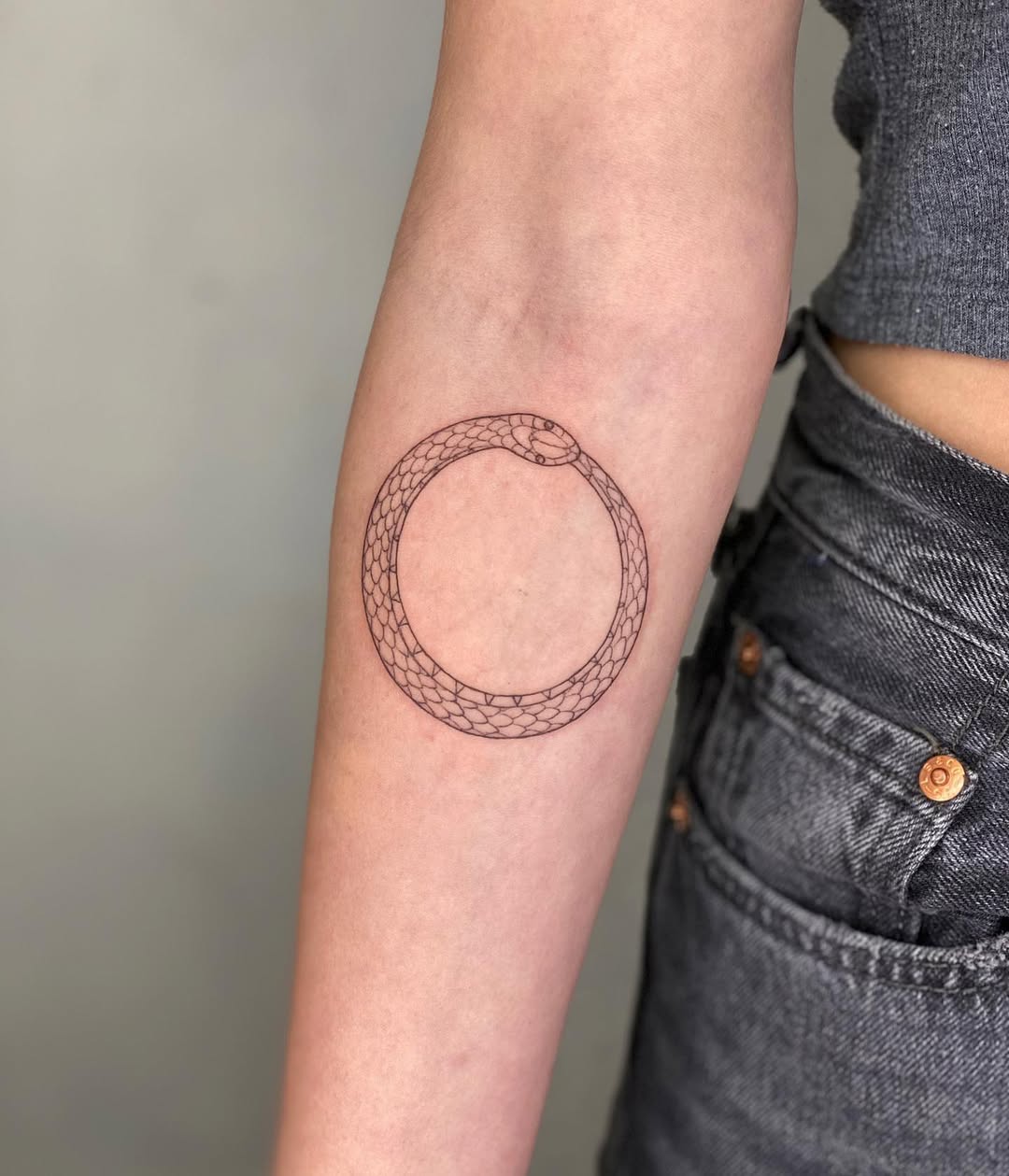 Minimalist Ouroboros Tattoo Design on Arm