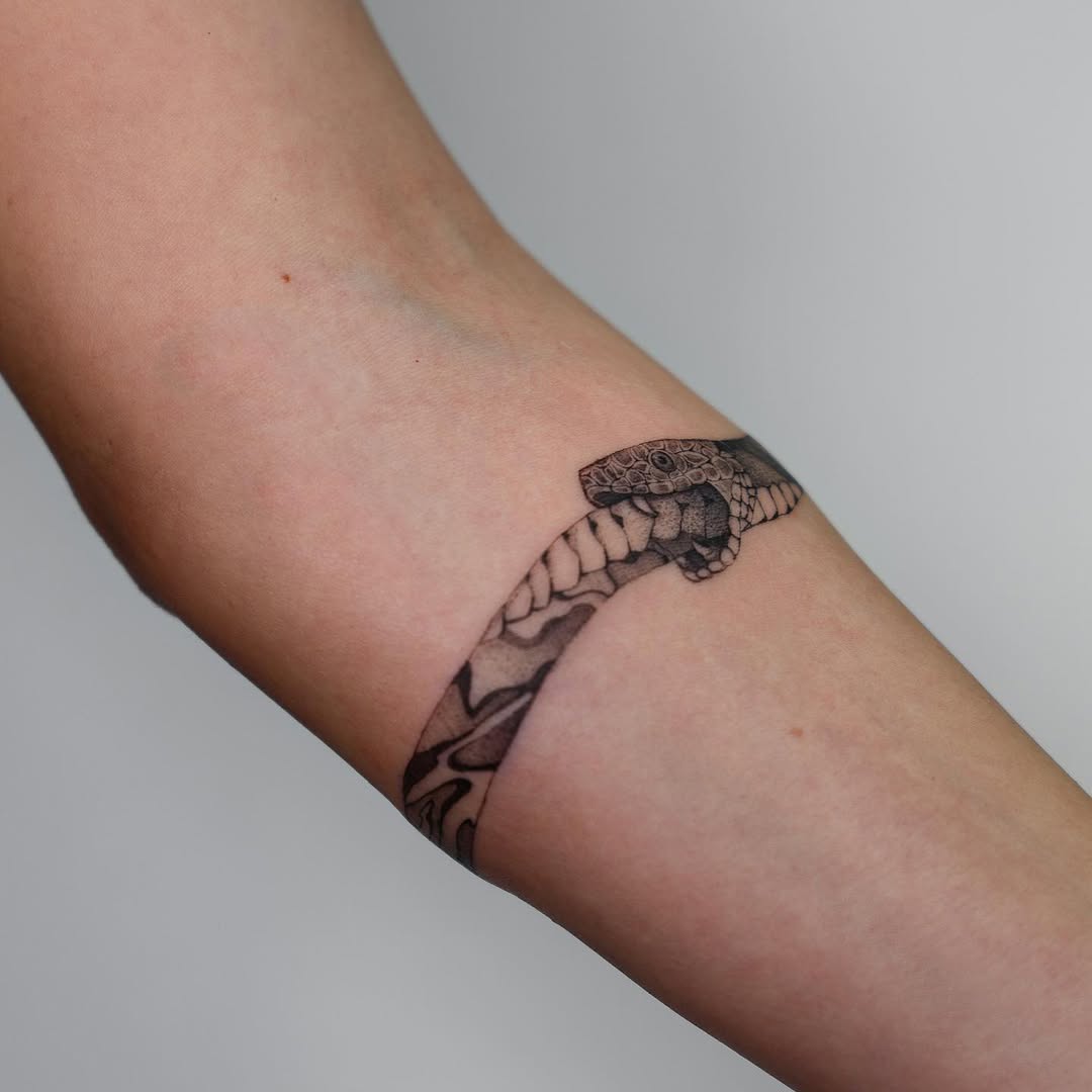 Stylish ouroboros tattoo wrapping the arm