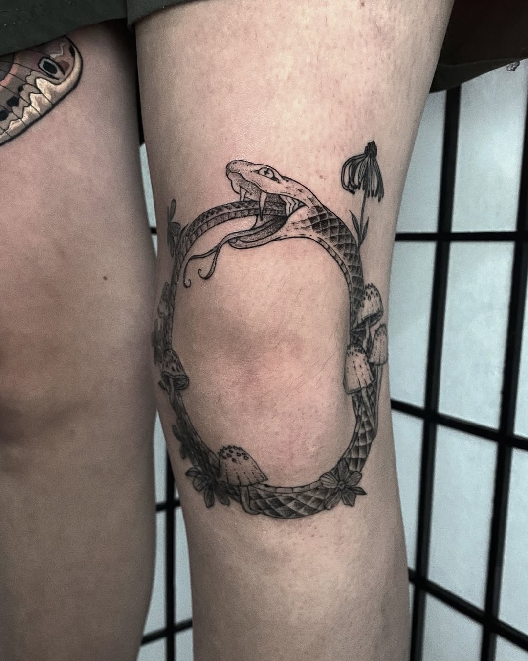 Intricate ouroboros design with floral elements