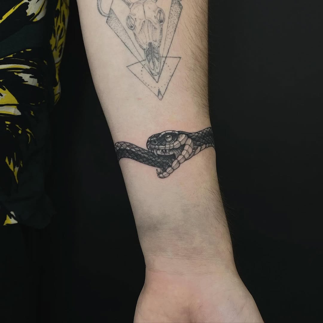 Intriguing ouroboros tattoo wrapped around forearm