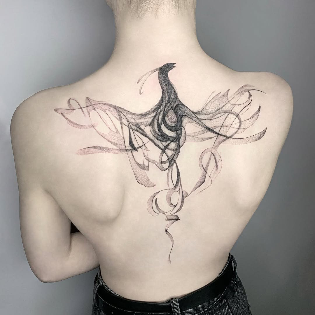 Elegant swirling phoenix tattoo on the back