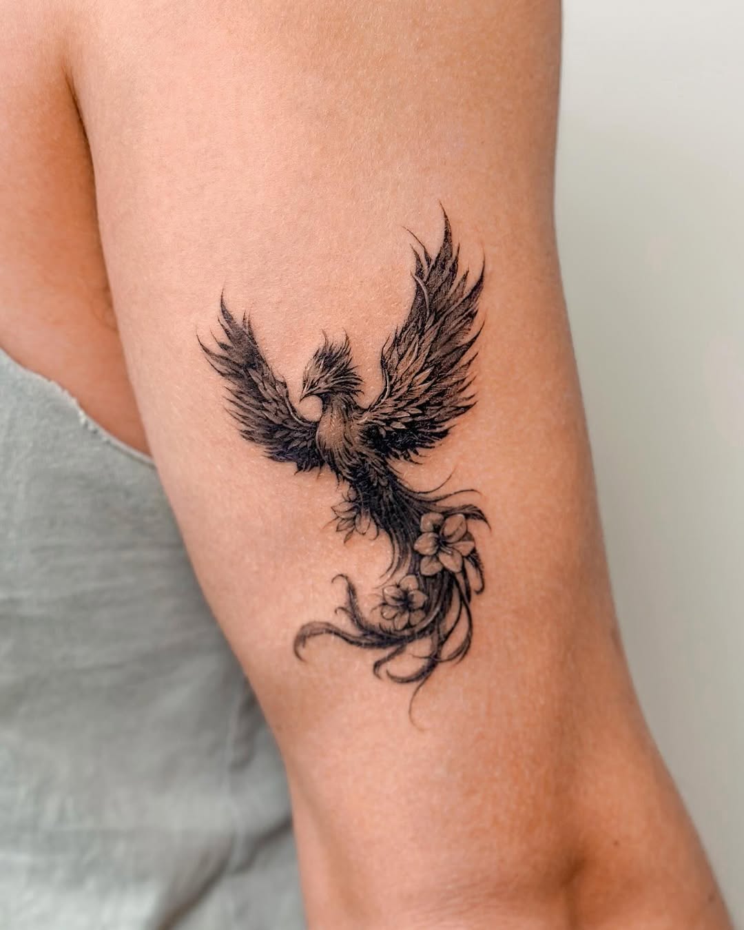 Elegant phoenix tattoo with floral elements