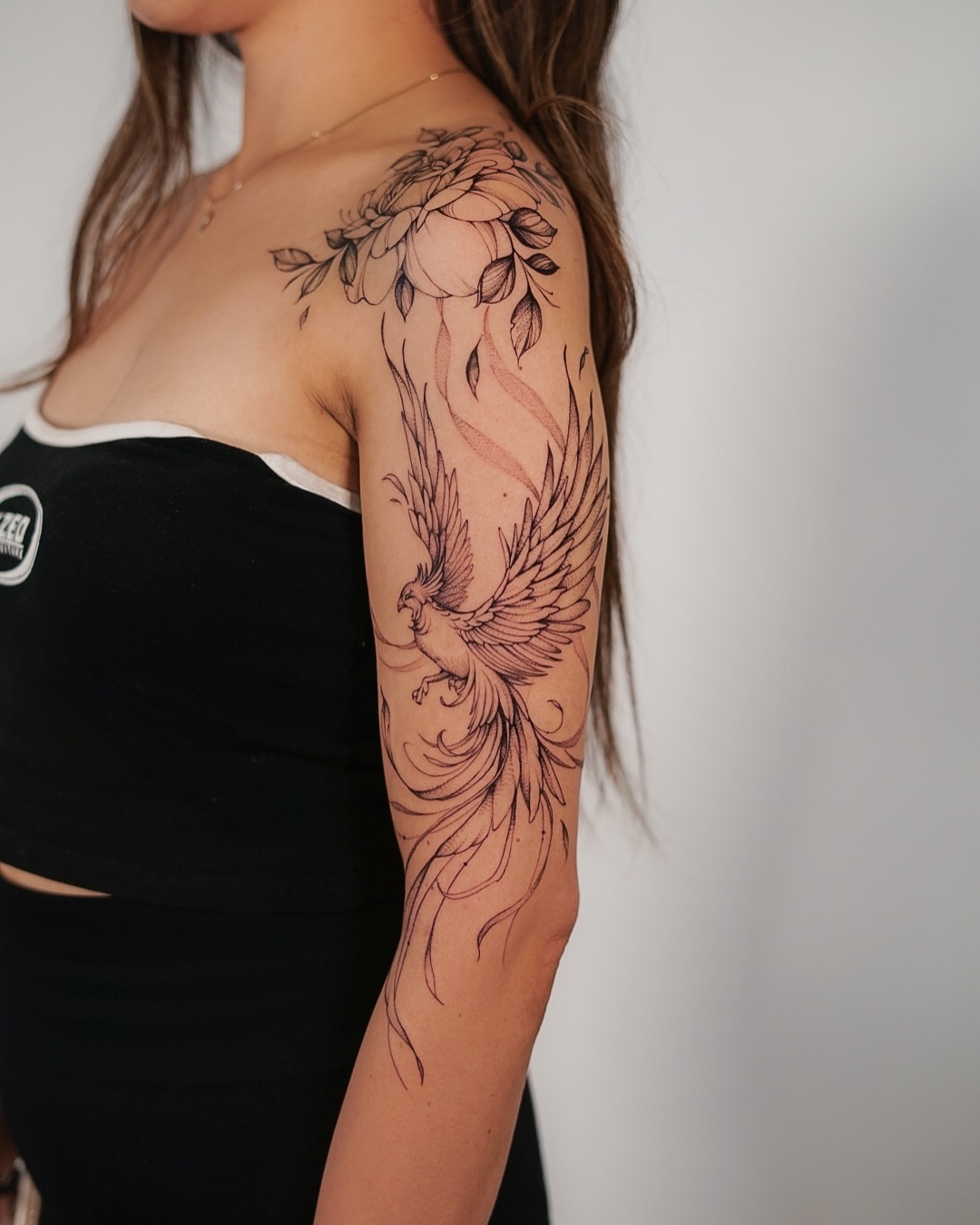 Elegant phoenix tattoo with floral embellishments