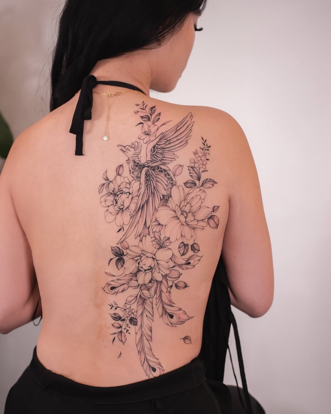 Elegant phoenix tattoo with floral elements