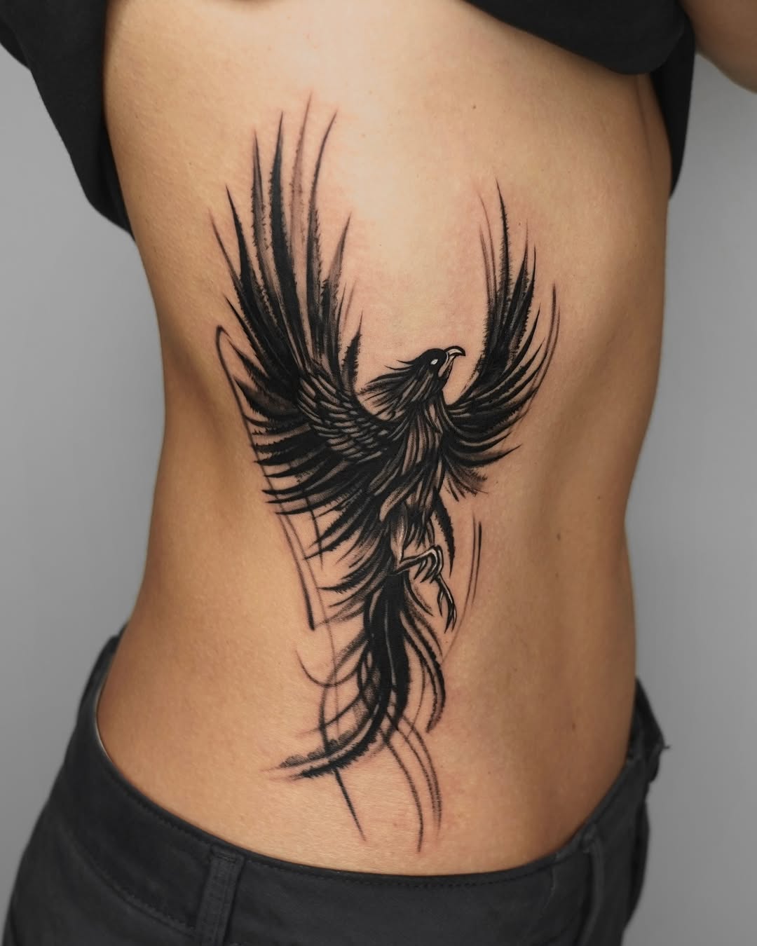 Dynamic phoenix tattoo design on side body