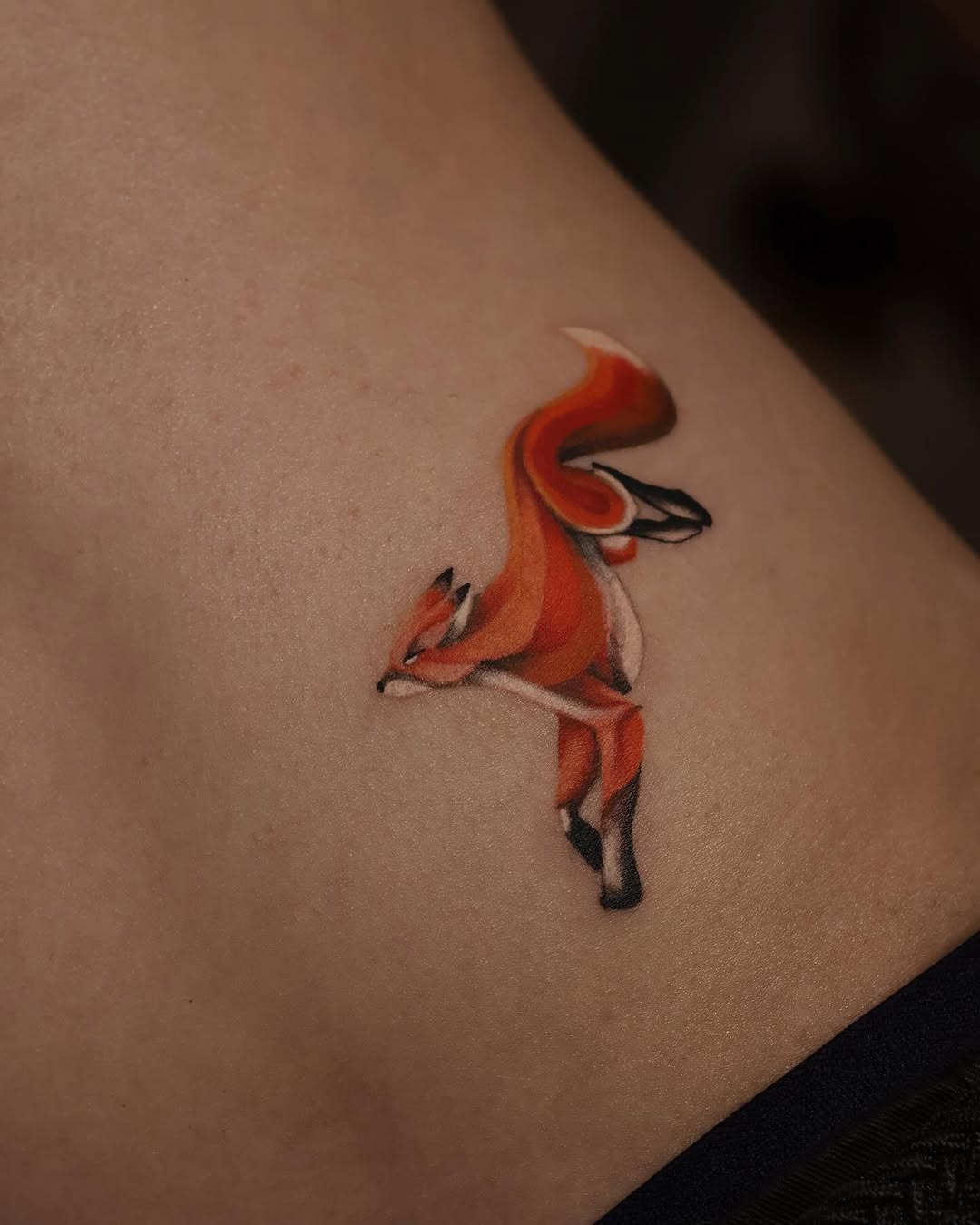 Whimsical fox tattoo on a person's skin