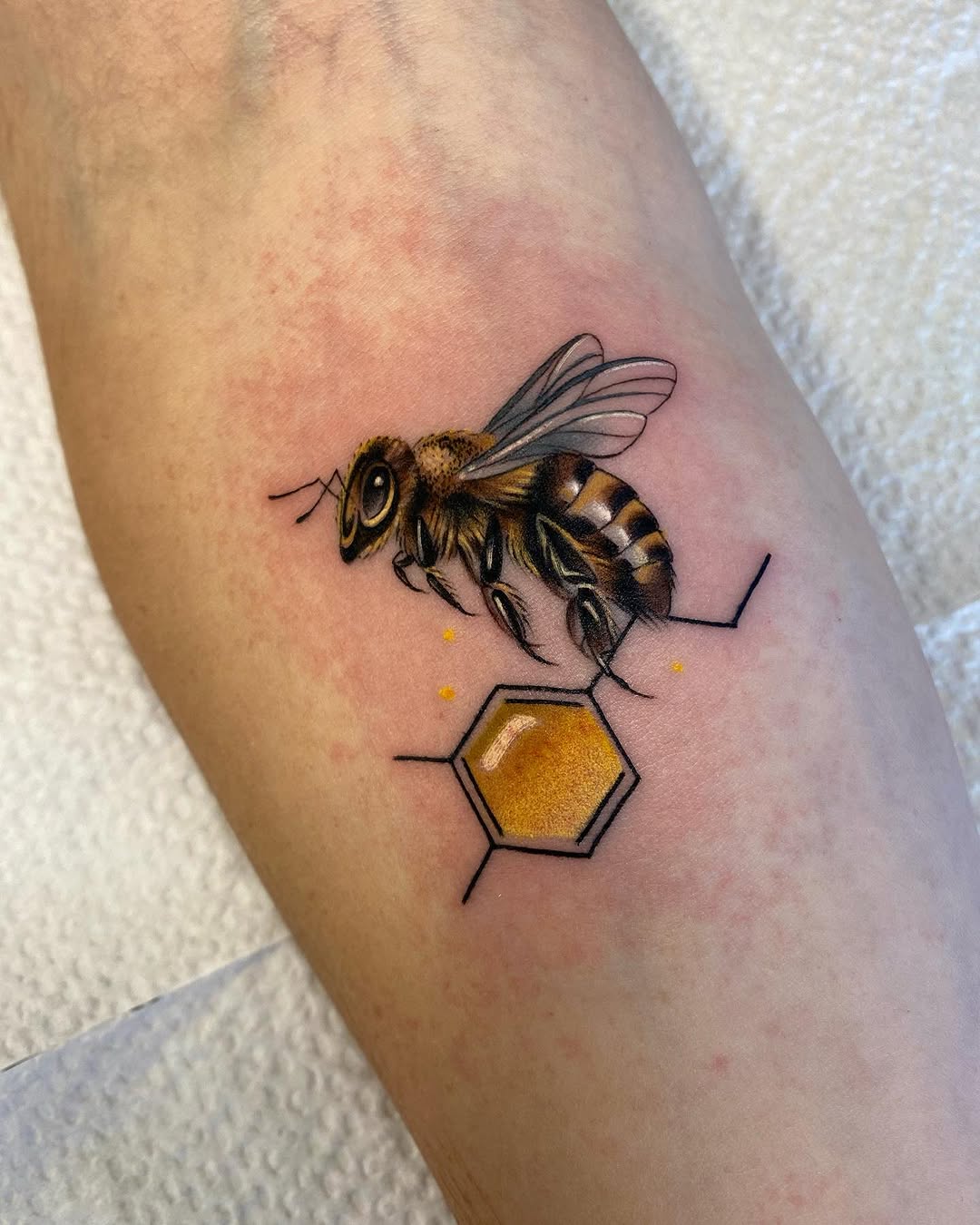 Stunning realistic bee and honeycomb tattoo