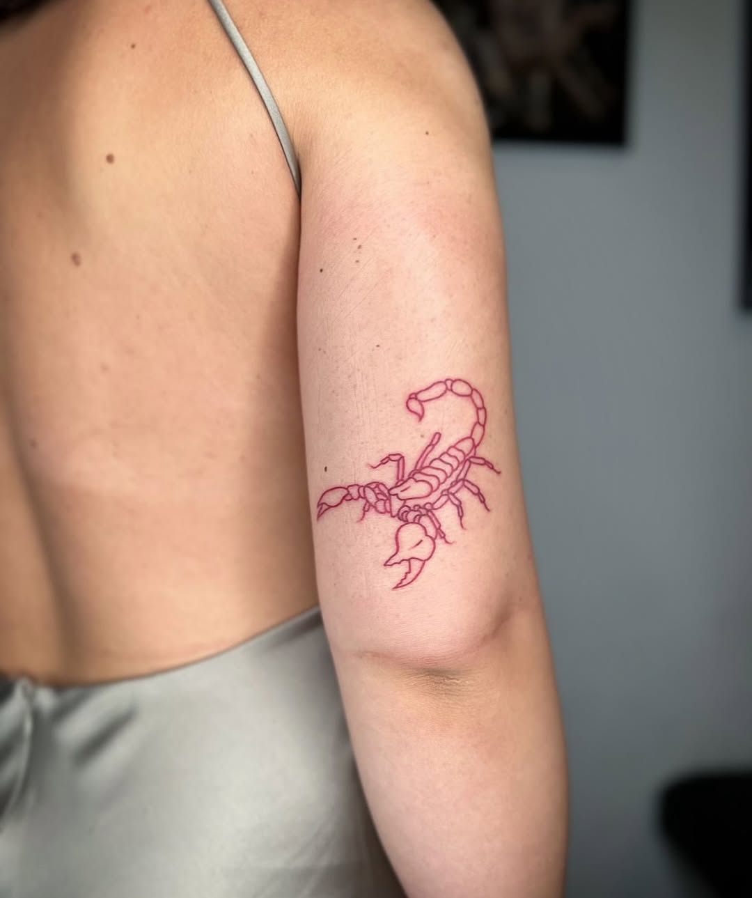 Elegant red scorpion tattoo on arm