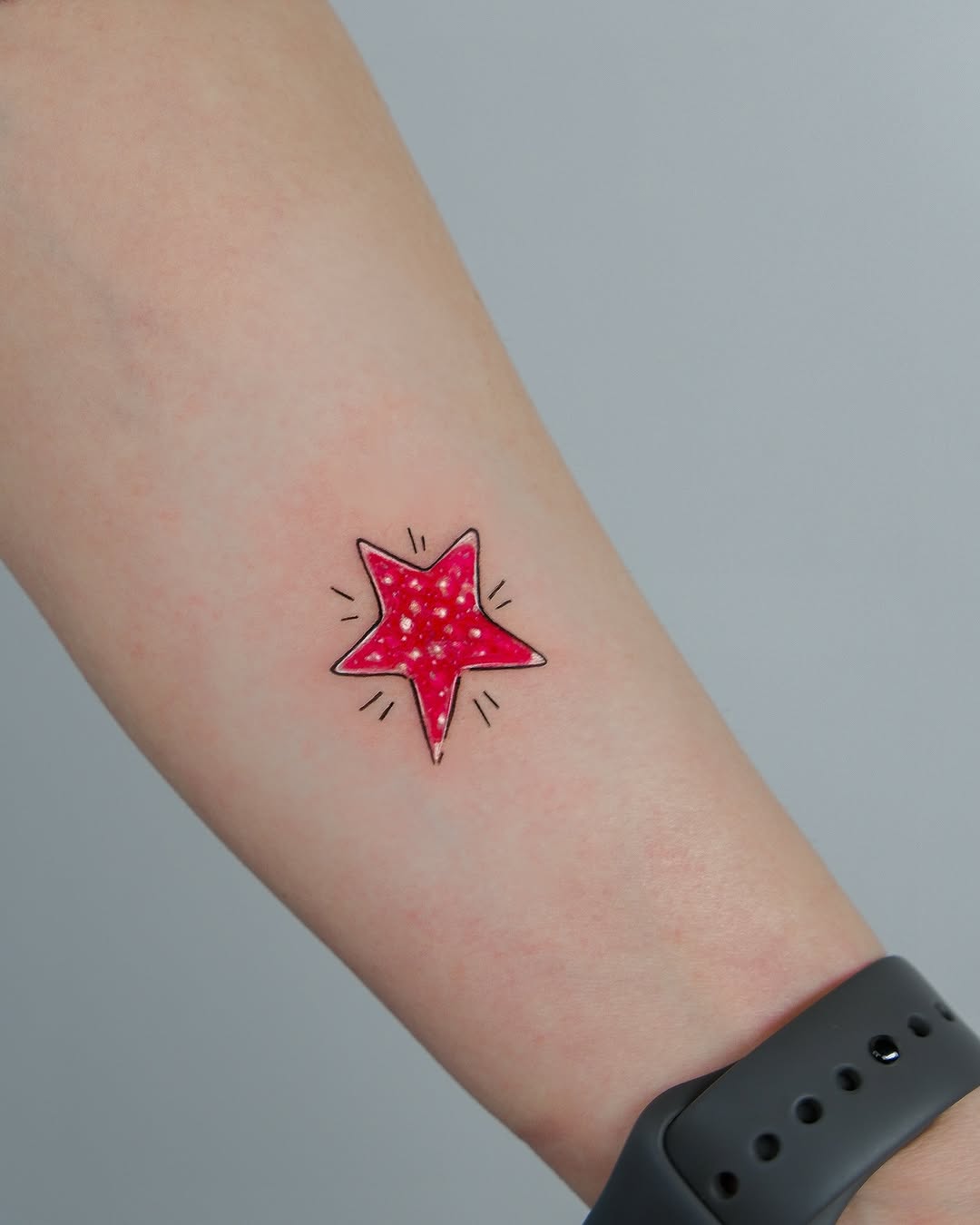 Vibrant Red Star Tattoo on Forearm