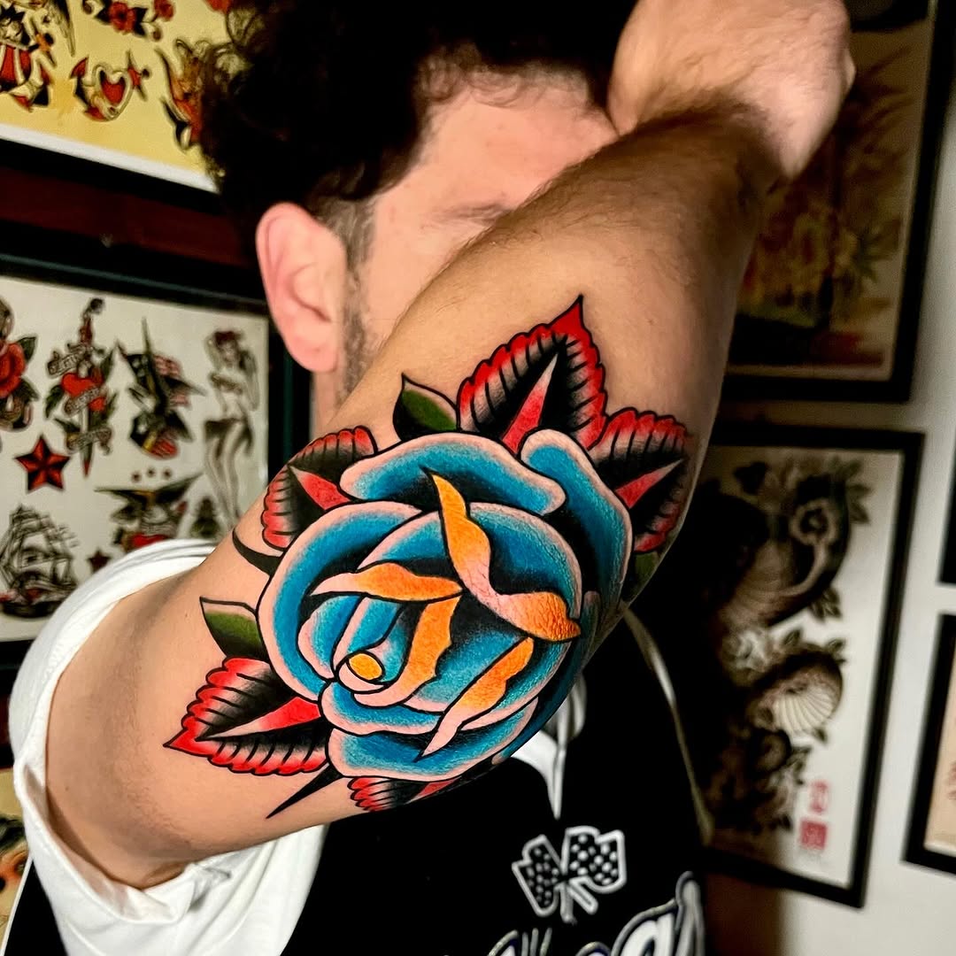 Vibrant rose elbow tattoo with colorful accents