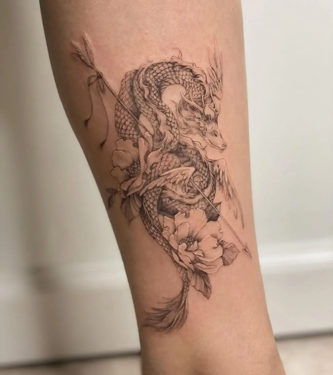 Elegant dragon tattoo with floral elements