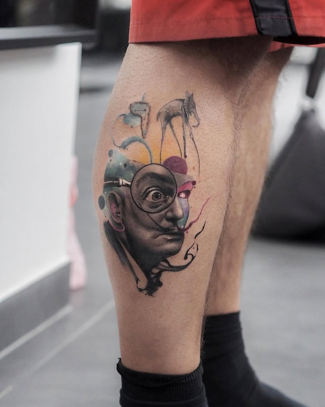 Surreal Salvador Dali-inspired leg tattoo design