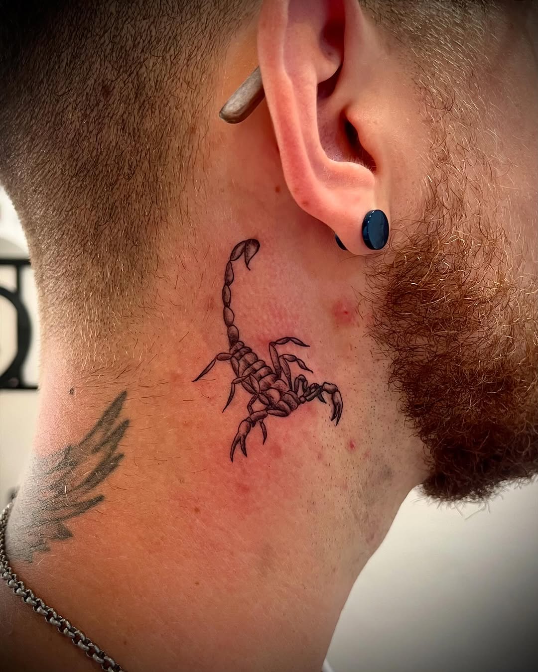 Intricate Scorpio tattoo near the ear