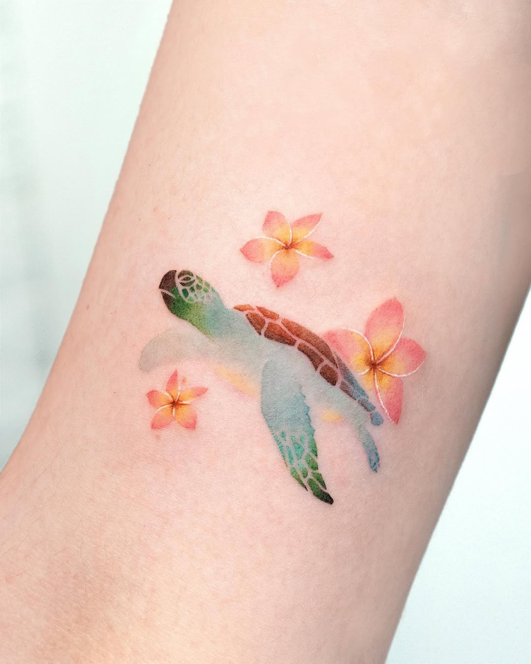 Vibrant watercolor turtle tattoo with flowers