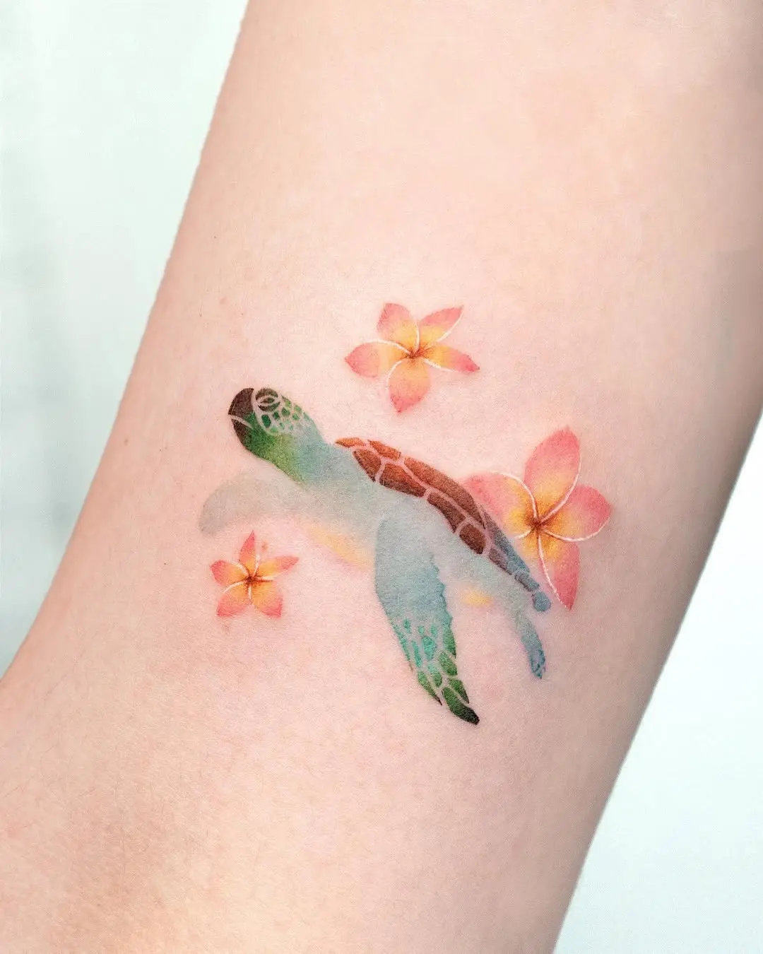 Vibrant watercolor turtle tattoo with flowers