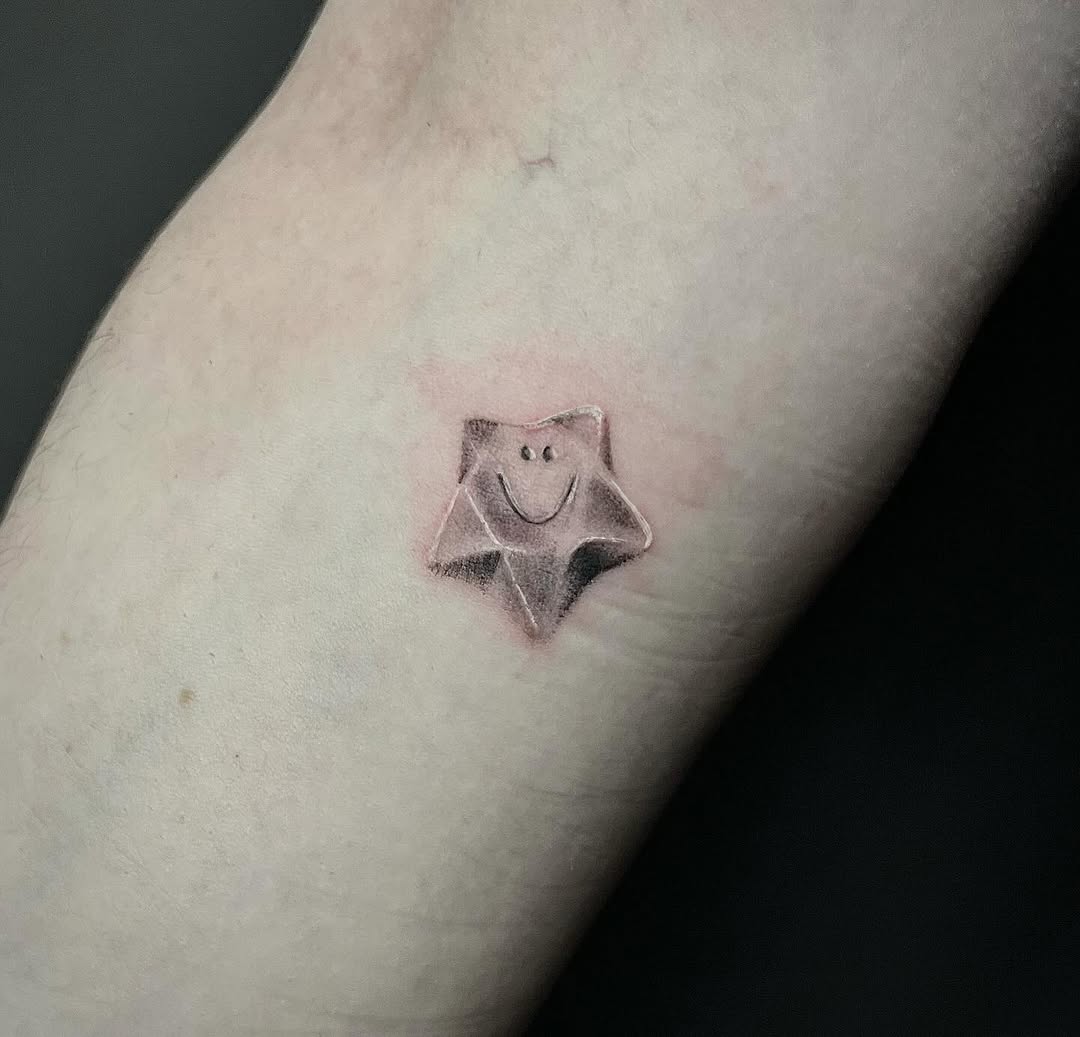 Whimsical smiling star tattoo on the skin