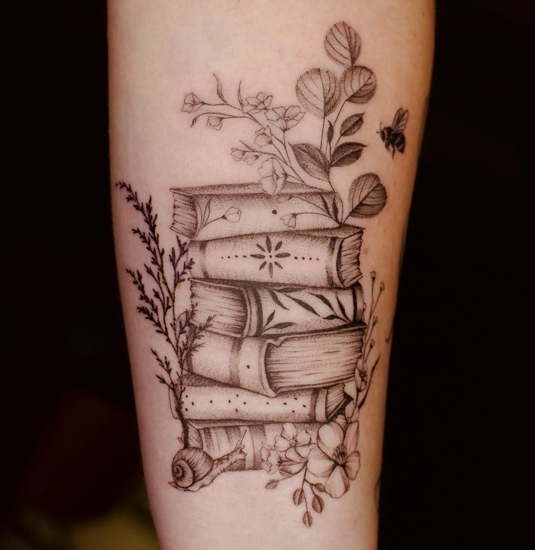 Artistic book stack with floral elements tattoo