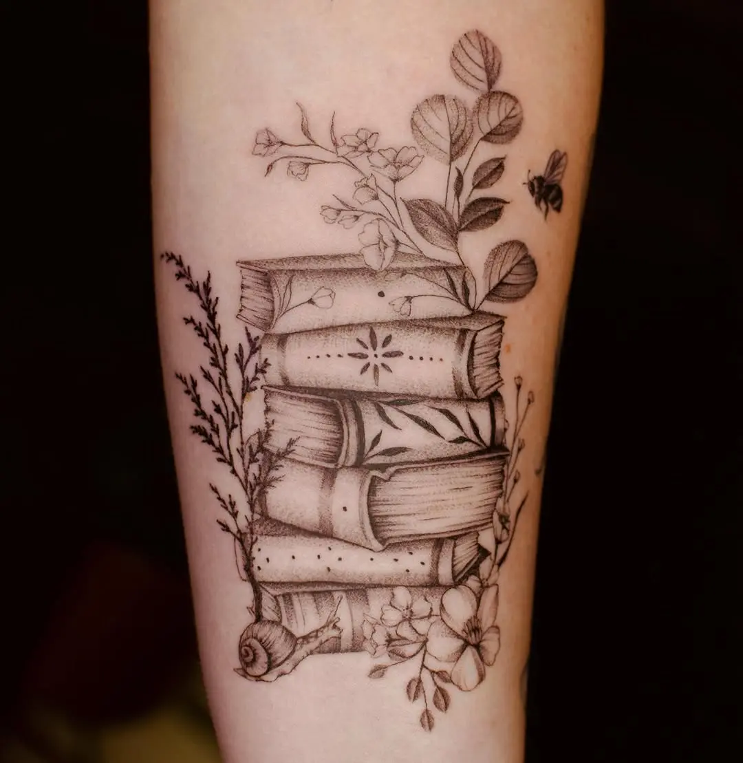 Artistic book stack with floral elements tattoo