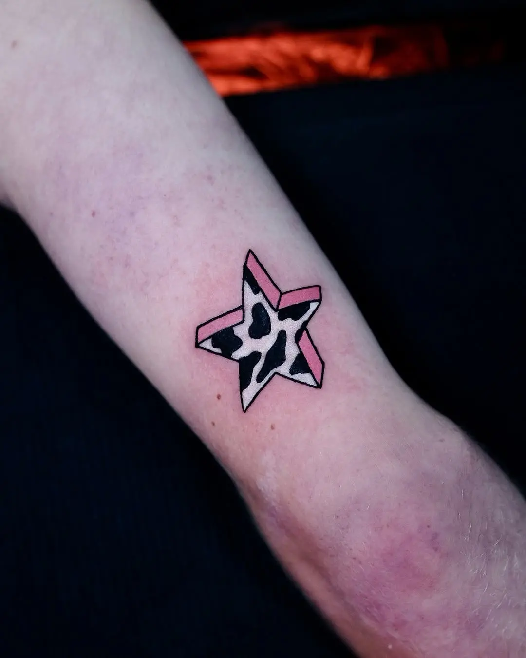 Bold star tattoo with playful patterns and colors