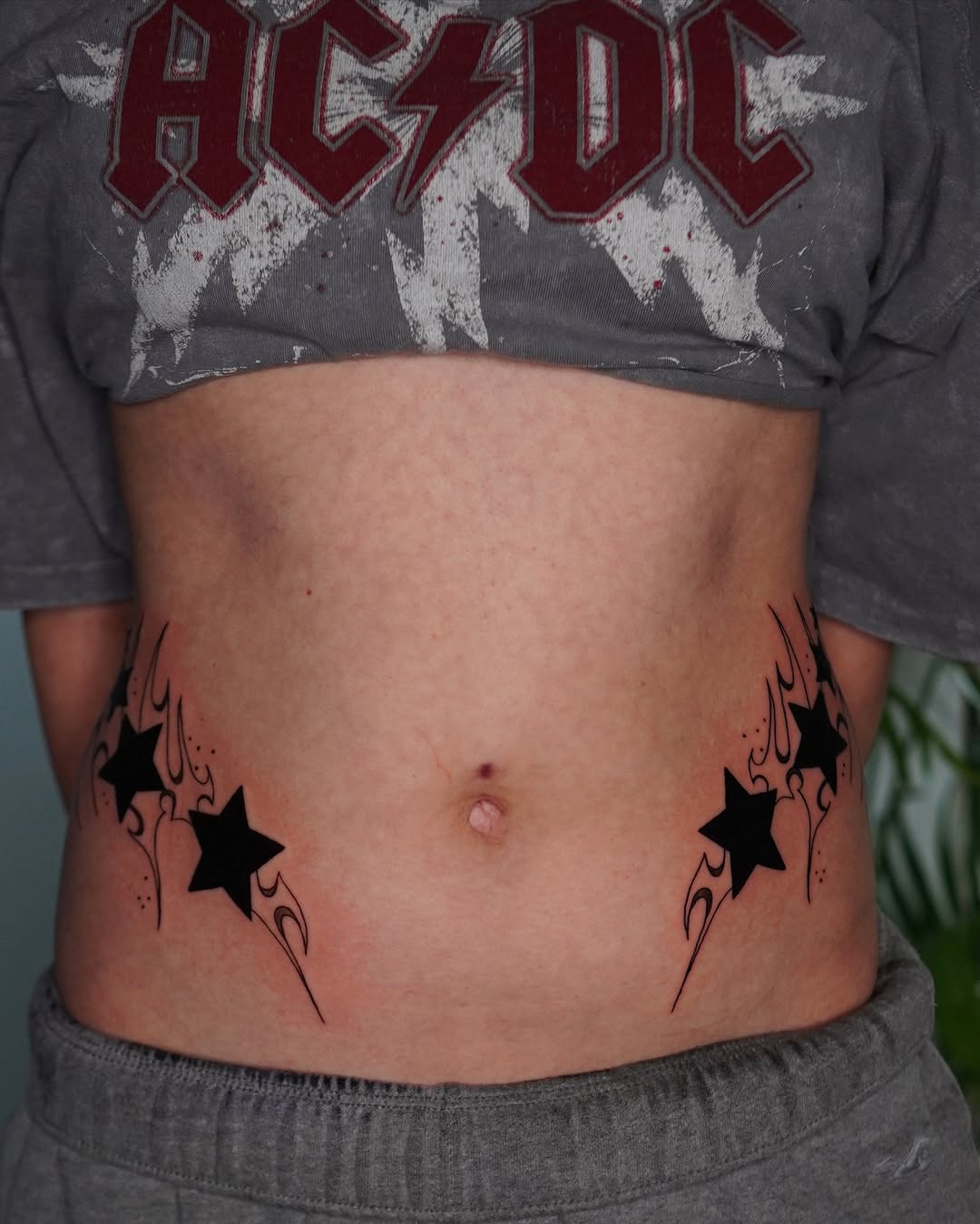 Bold star tattoos with artistic flair on belly