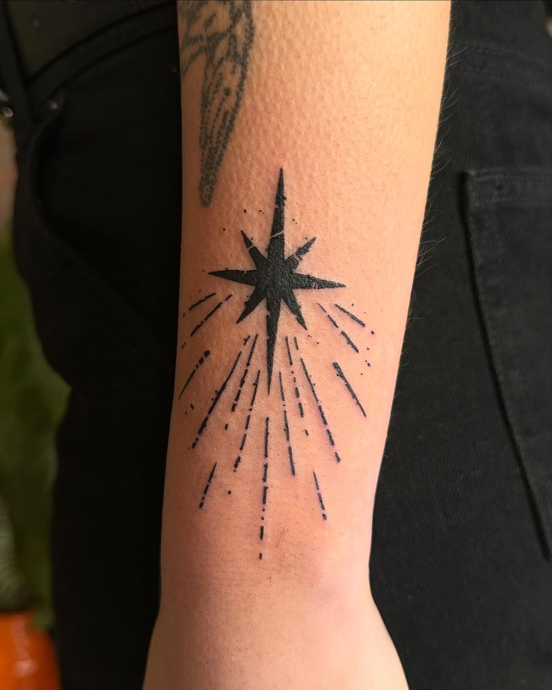 Radiant star tattoo with expressive rays