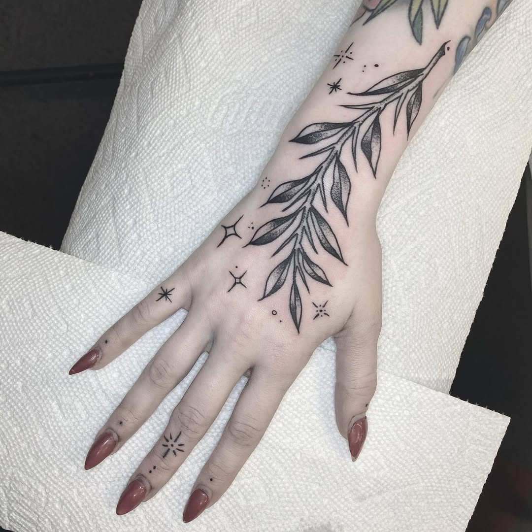 Elegant star and leaf tattoo design on hand