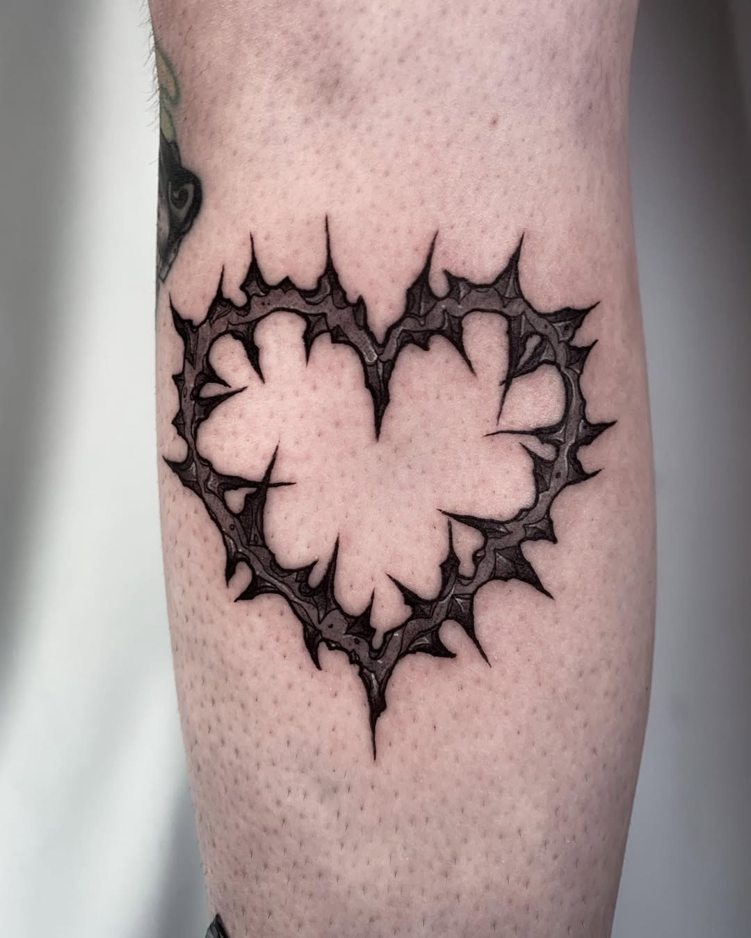 Stylish thorn-covered heart tattoo design