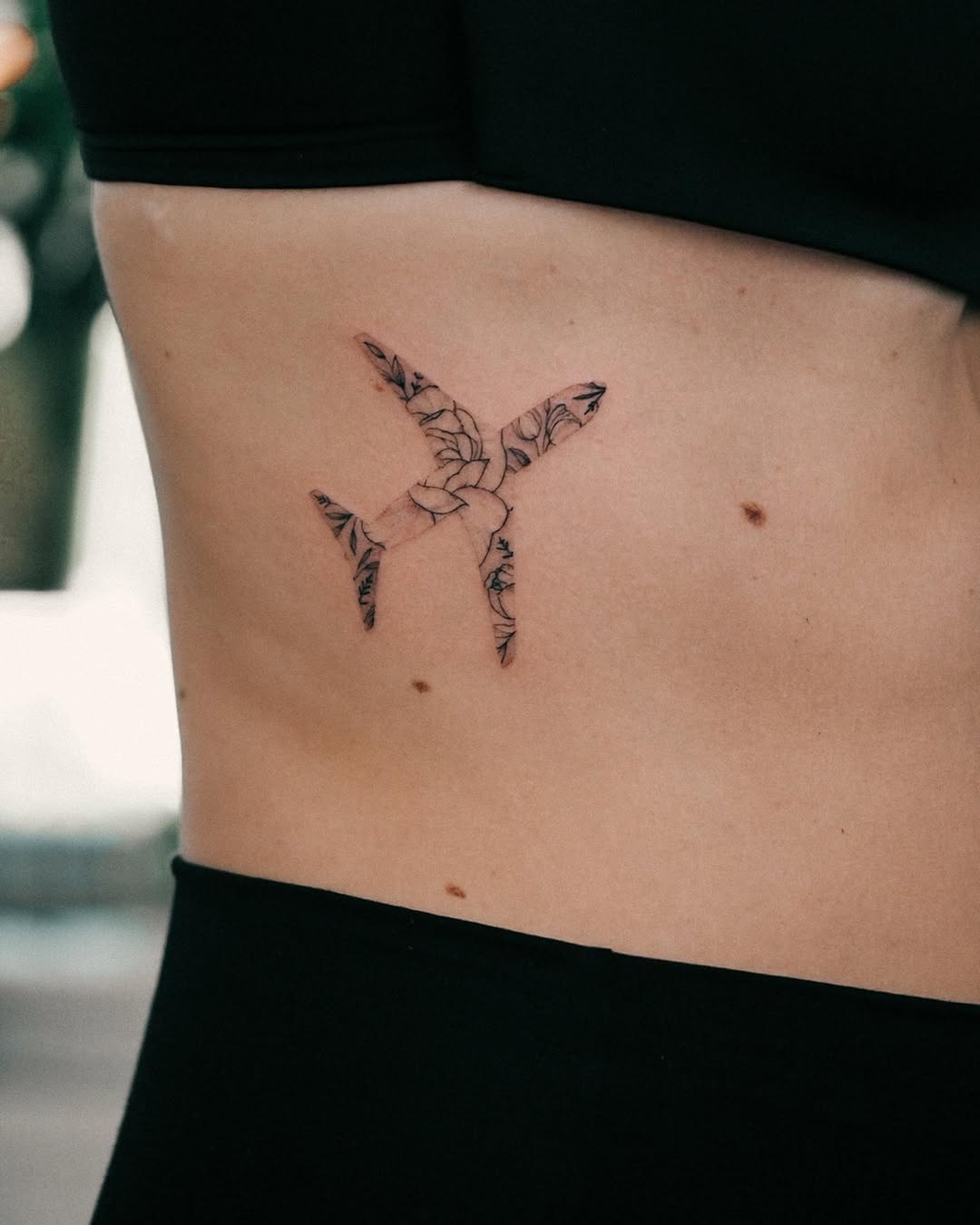 Stylish airplane tattoo with floral details