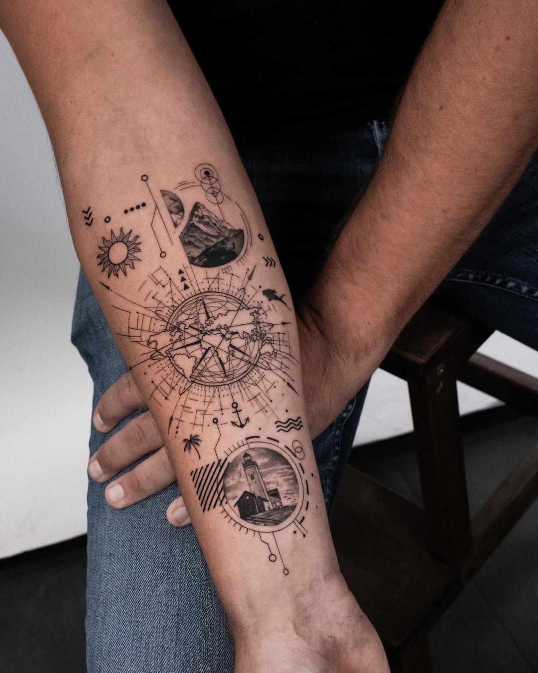 Intricate compass and landscape tattoo design.