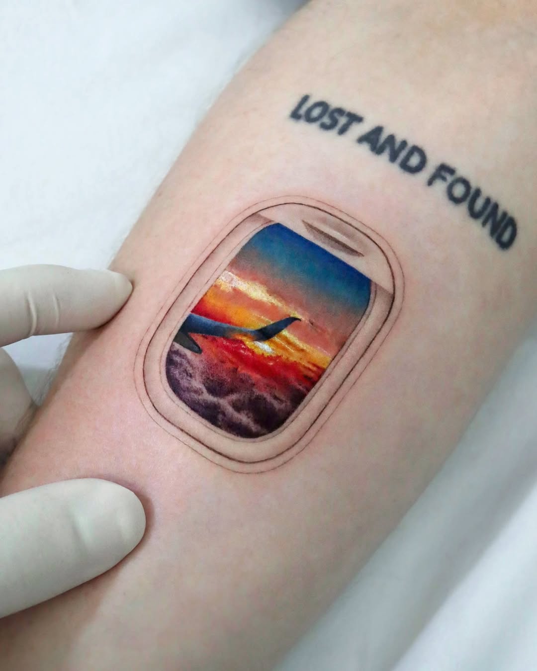 A stunning plane window sunset tattoo