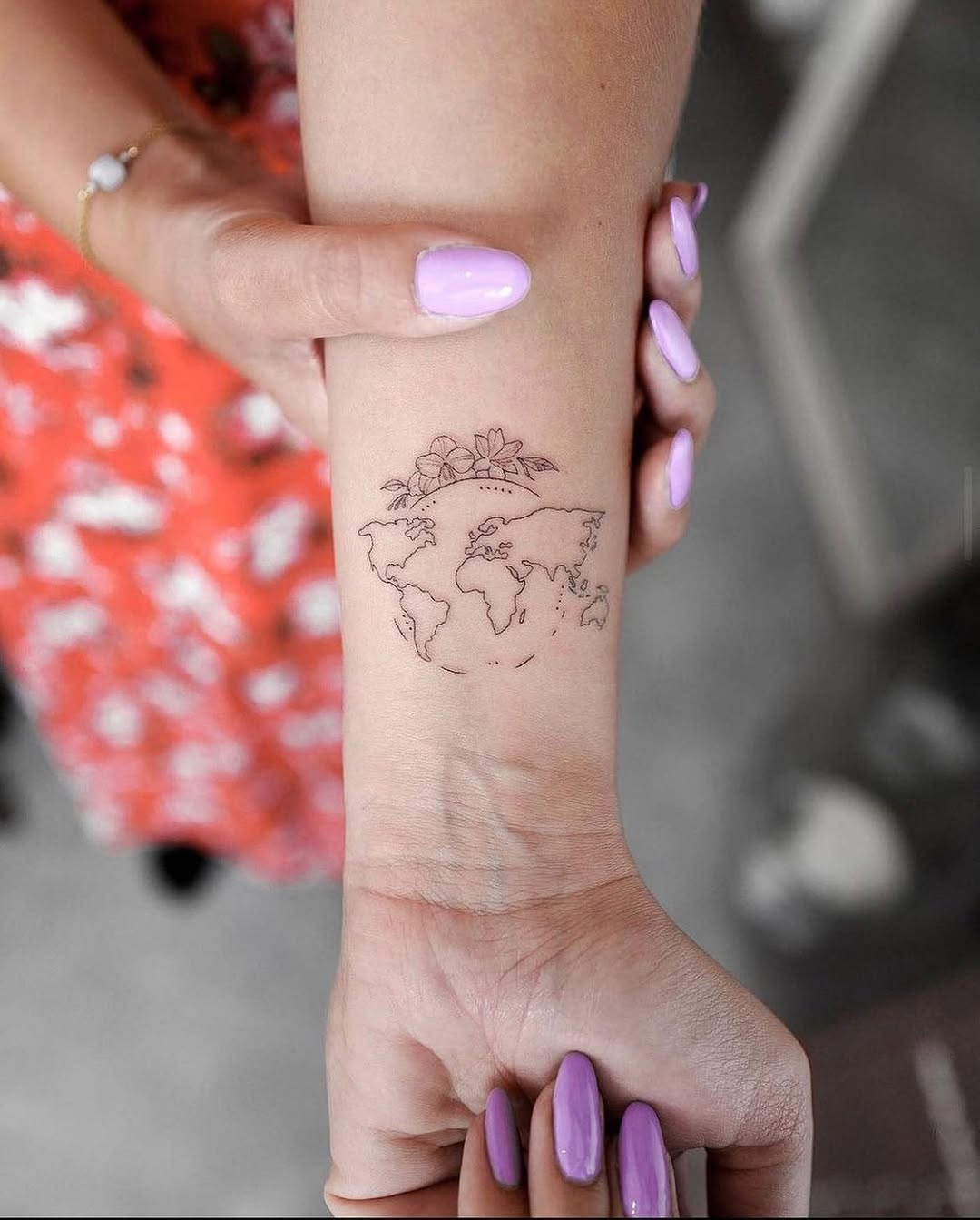 Delicate world map tattoo with floral details