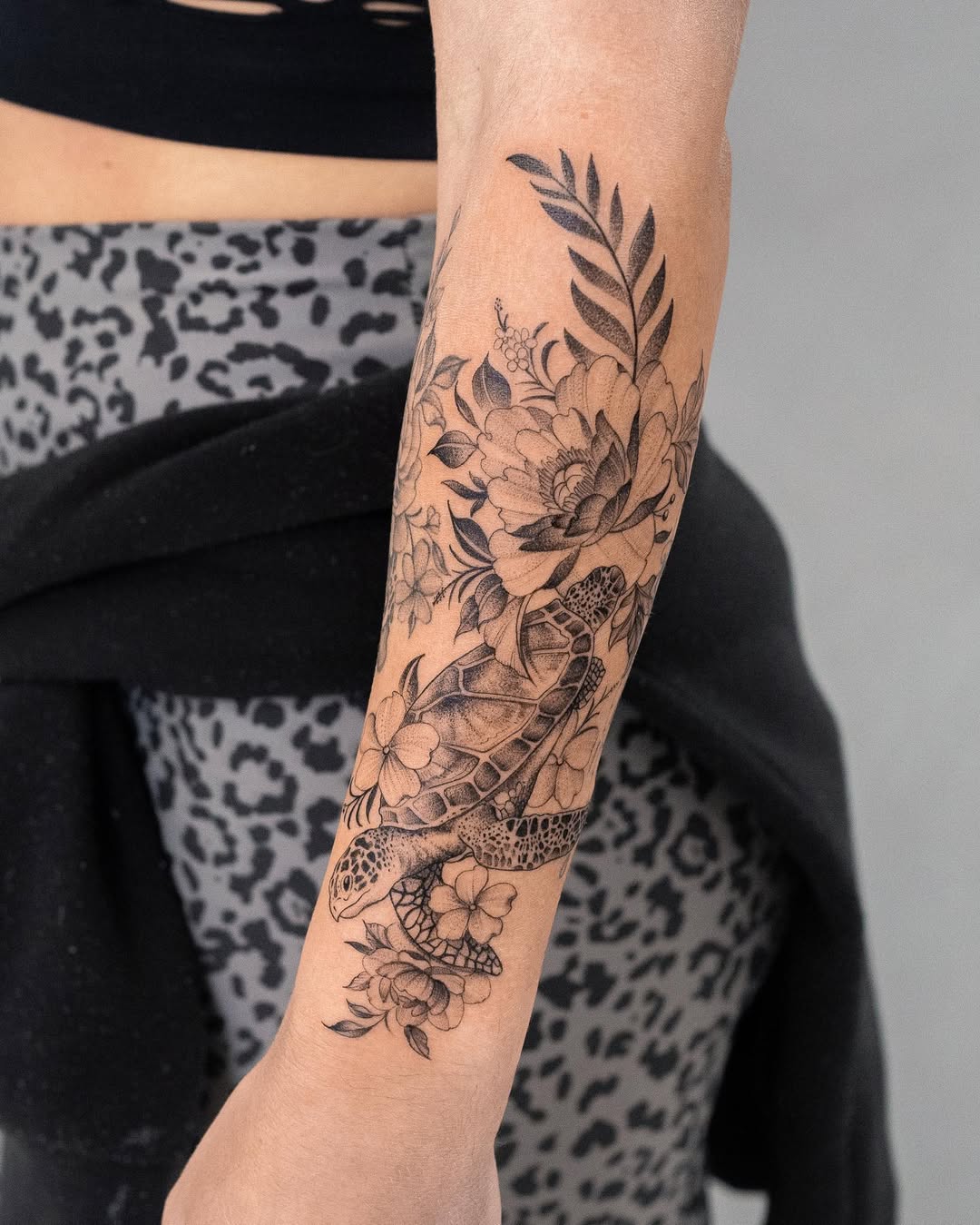 Elegant floral turtle tattoo on the forearm