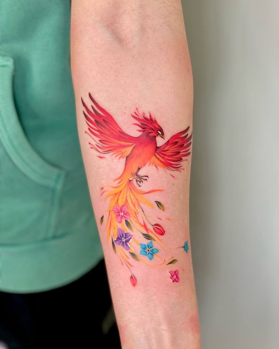 Stunning phoenix tattoo with vibrant floral accents