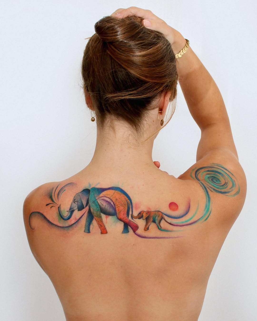 Vibrant watercolor family elephant tattoo concept