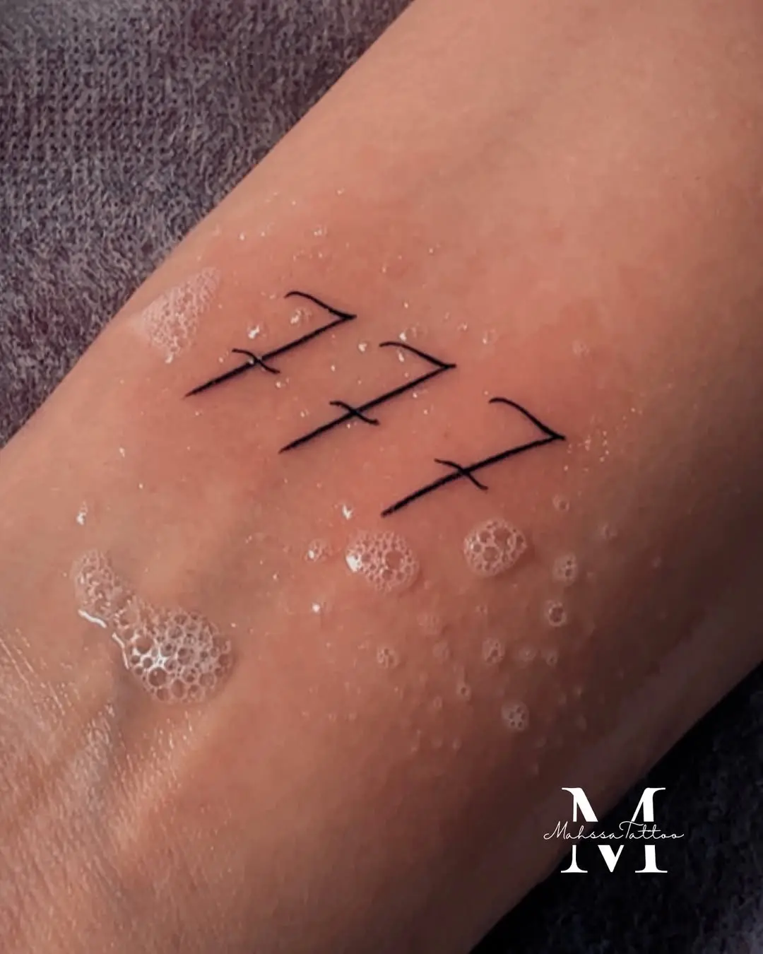 Elegant 777 angel number tattoo design