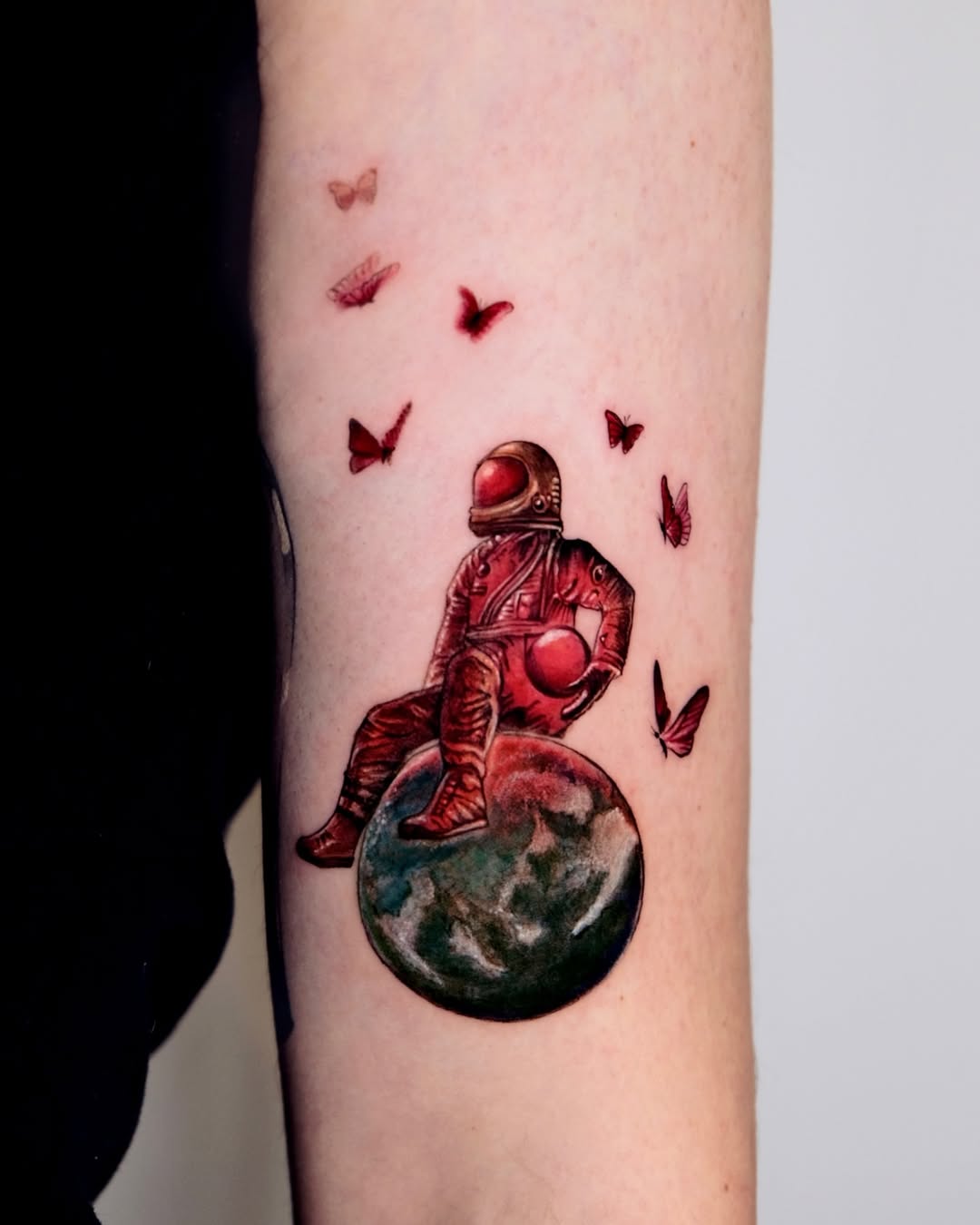 Vibrant astronaut tattoo with butterflies and globe