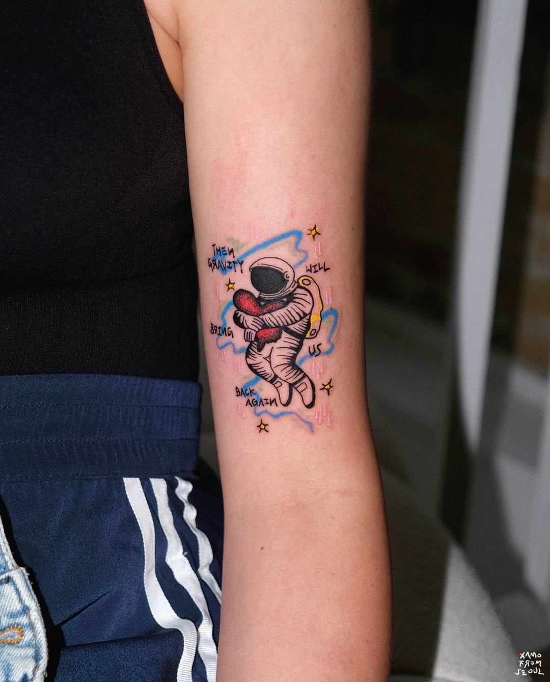 Adorable astronaut tattoo with a cosmic theme