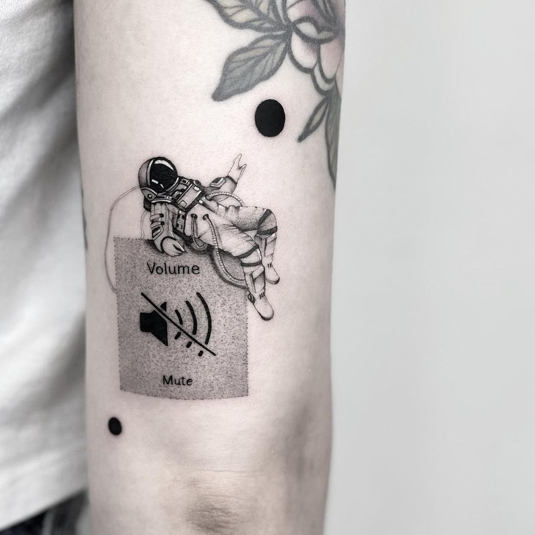 Creative tattoo blending astronaut and sound controls