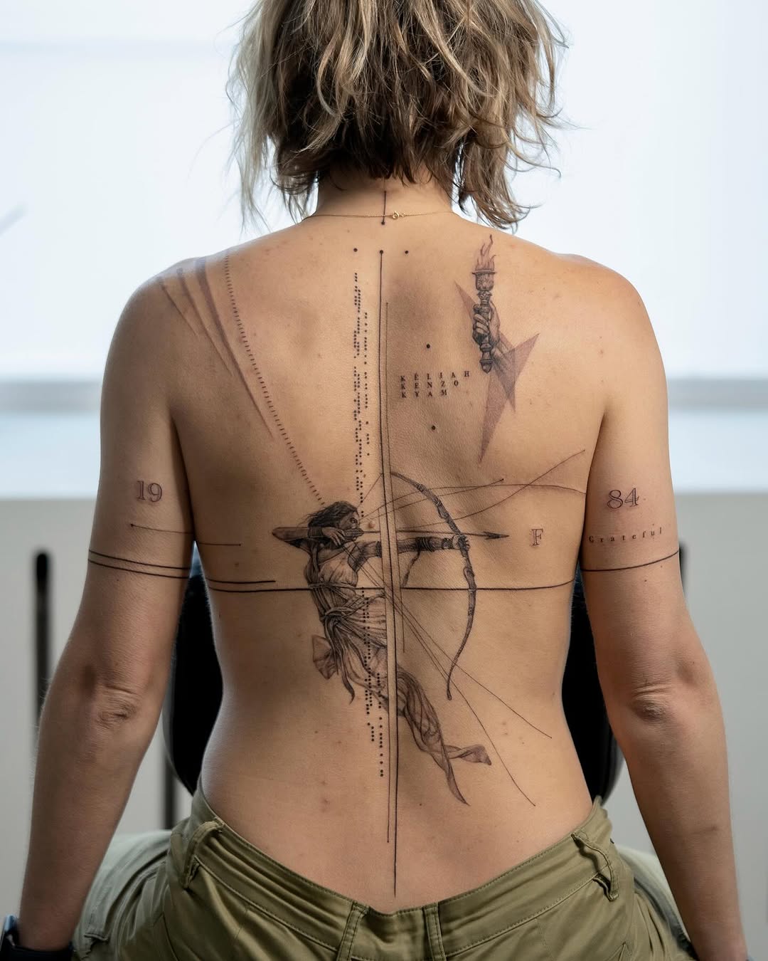 Intricate back tattoo design featuring an archer