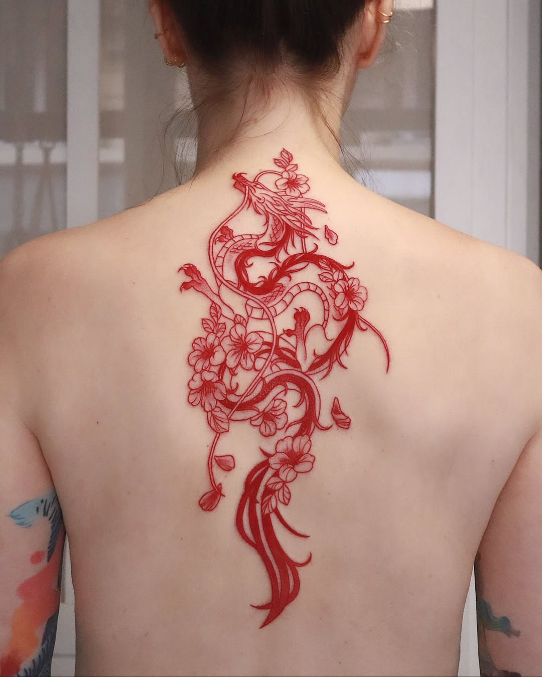 Striking red dragon and floral back tattoo