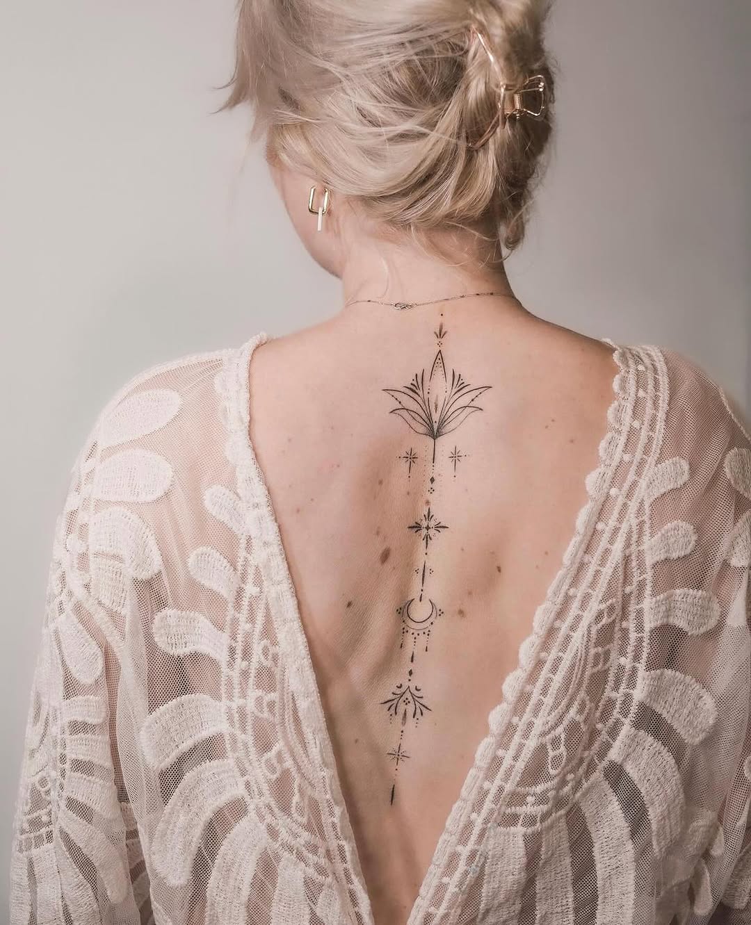 Elegant back tattoo featuring celestial motifs