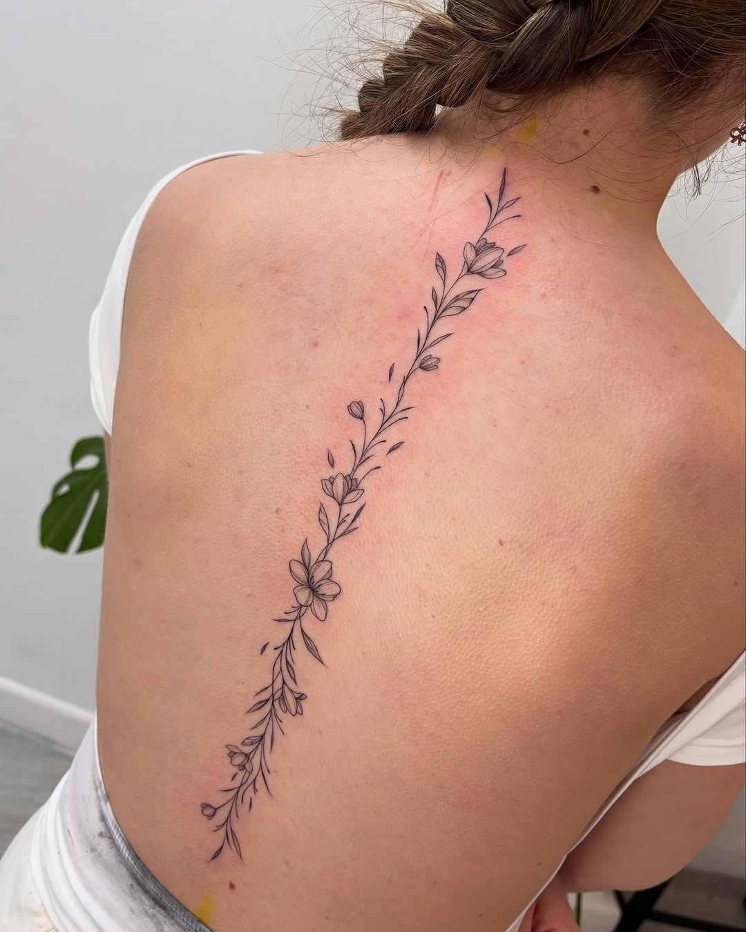 Elegant floral vine tattoo spanning the back