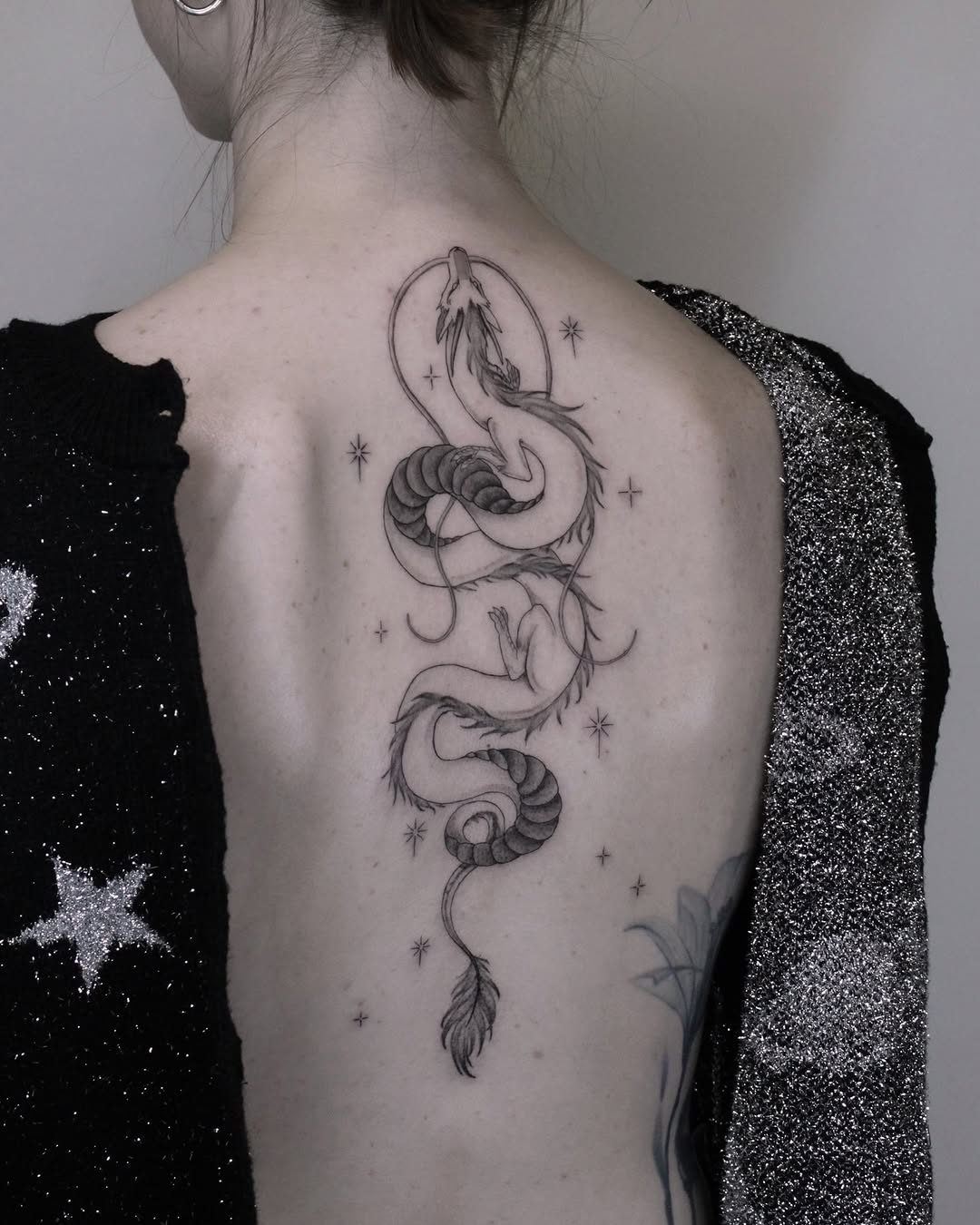 Elegant snake tattoo wrapping gracefully on back