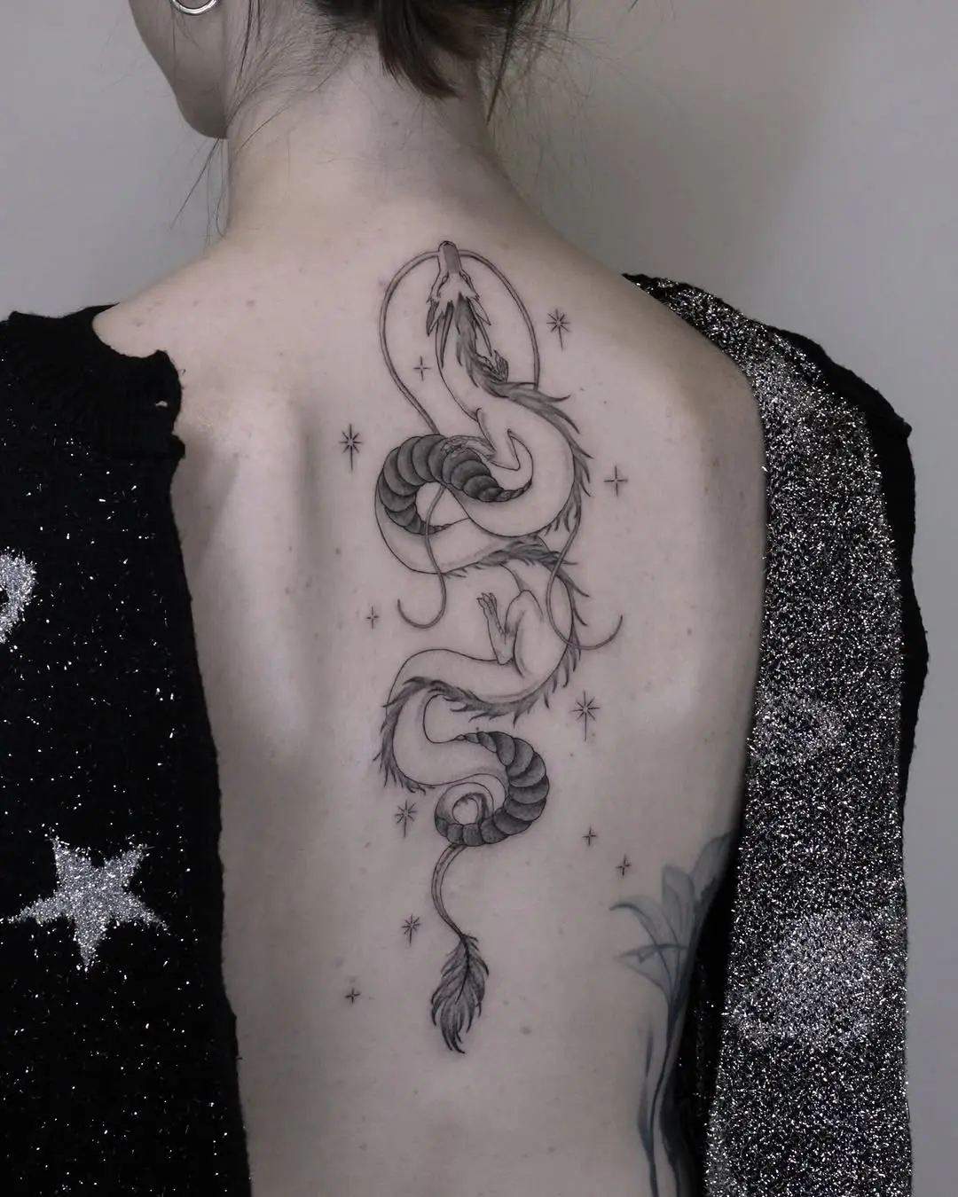 Elegant snake tattoo wrapping gracefully on back