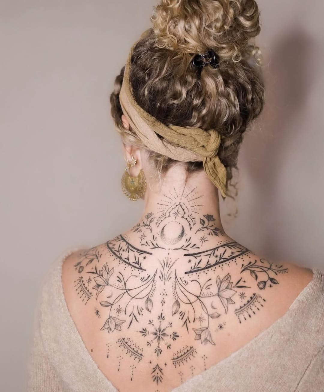 Intricate floral back tattoo design for women