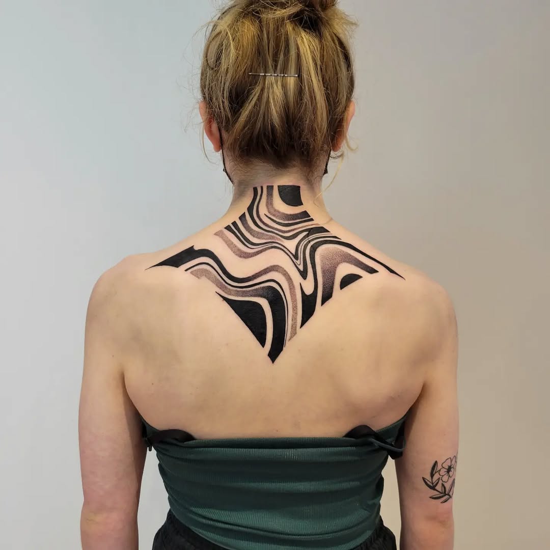 Modern abstract back tattoo with flowing patterns