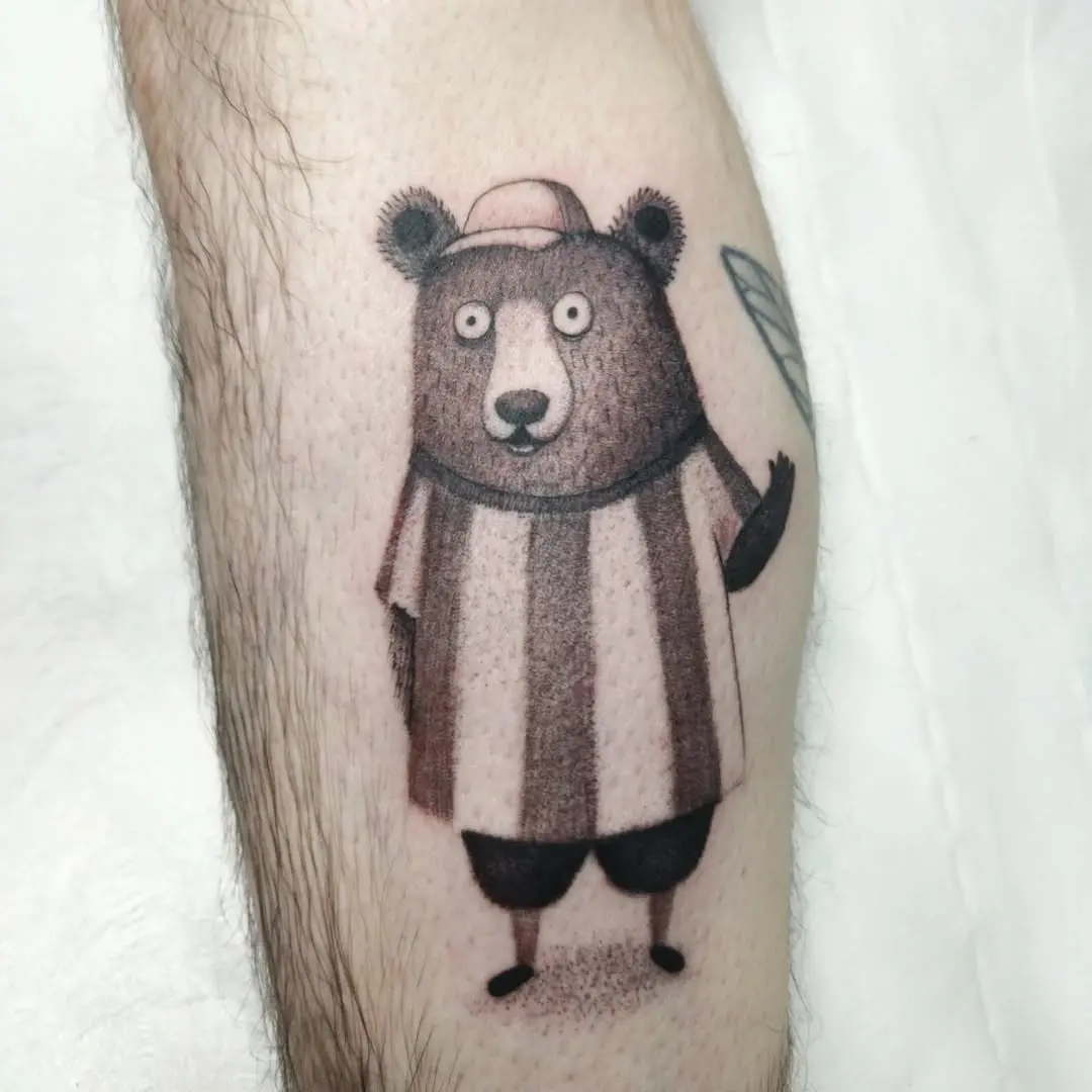 Playful cartoon bear tattoo with striped shirt